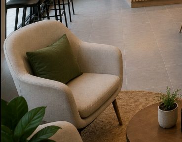 Green armchair with a cushion, plant and coffee mug